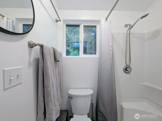 a bathroom with a toilet and a shower