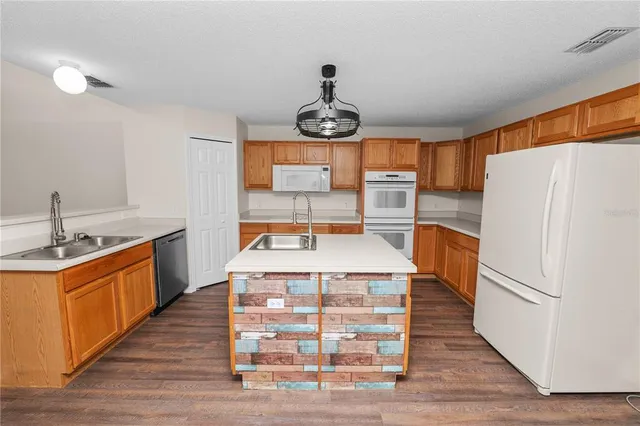 a kitchen with a stove and wooden floor