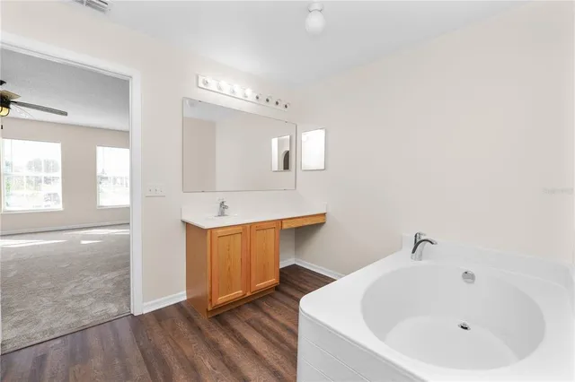a bathroom with a granite countertop sink a toilet and a tub
