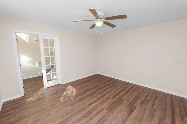 an empty room with wooden floor and windows