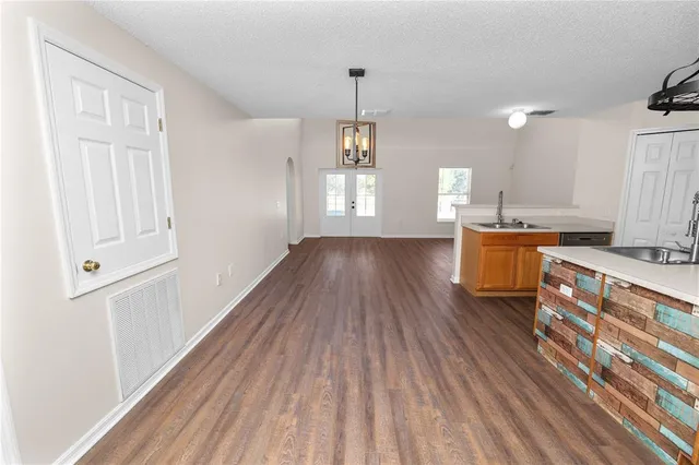 a view of a kitchen with wooden floor and electronic appliances