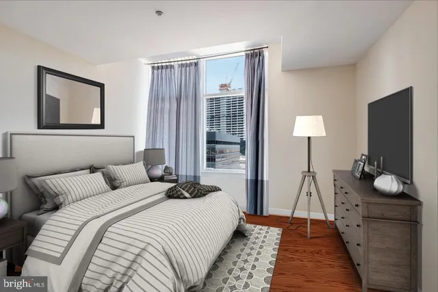 a bedroom with a bed and a flat tv screen on dresser