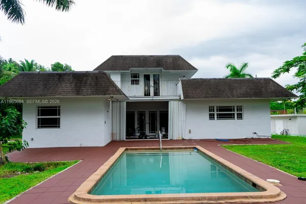 a view of a house with pool plants and a yard