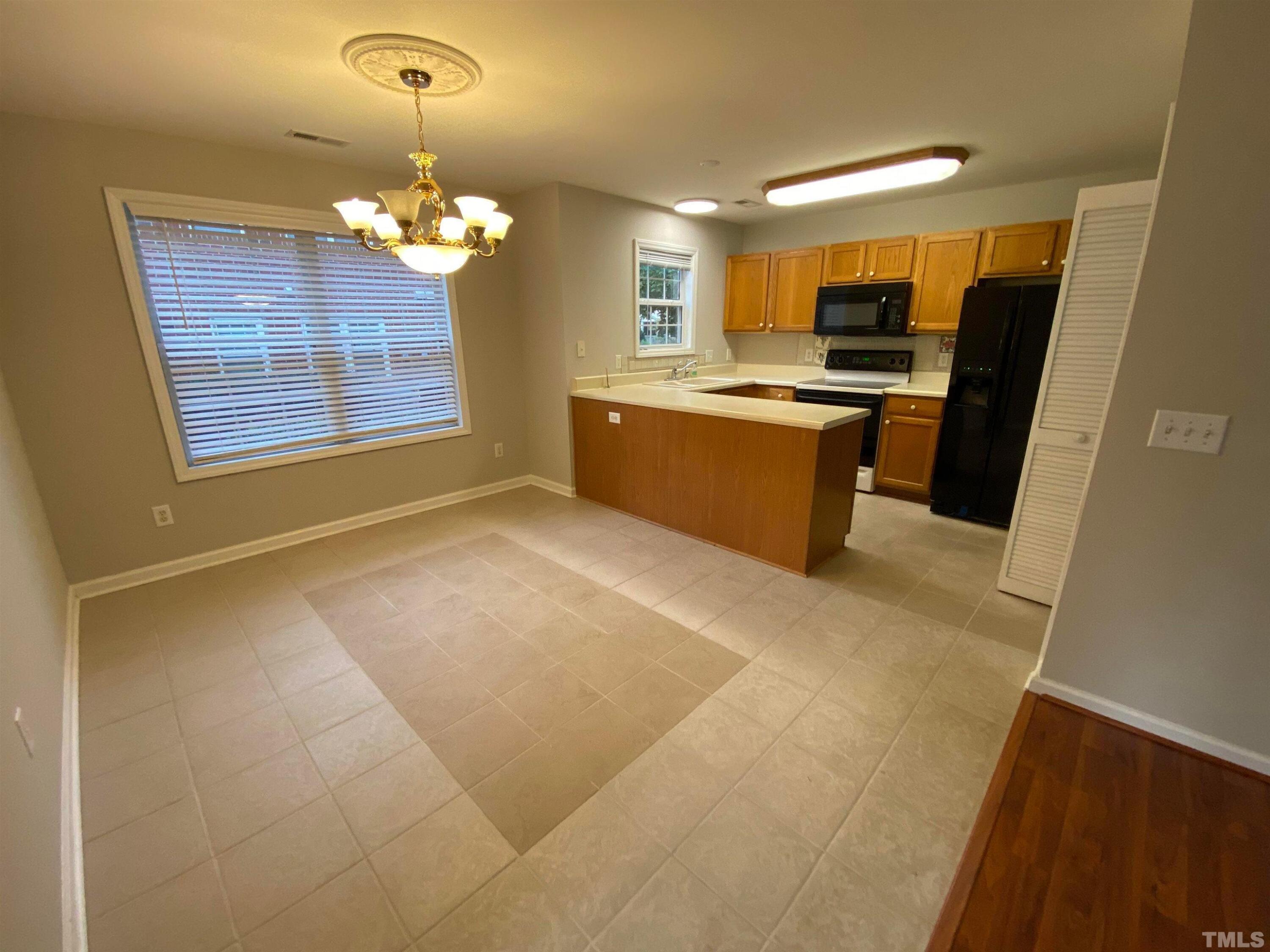2413 Wellington Ridge Loop, Unit 2413 Cary, NC 27518 - Photo 9 of 30 a large kitchen with a refrigerator a stove a sink dishwasher and a fireplace