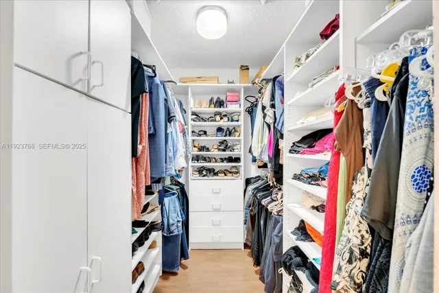 a view of walk in closet with clothes