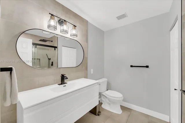a bathroom with a toilet a sink and mirror