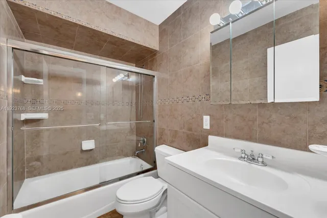 a bathroom with a bathtub shower sink mirror and toilet