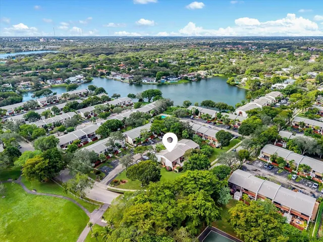 an aerial view of residential houses with outdoor space and lake view
