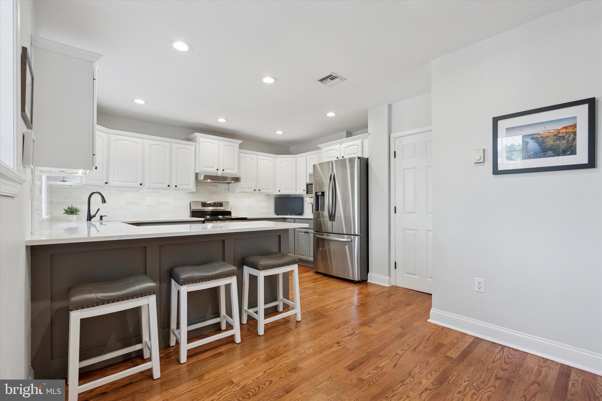 141 Friendship Road Drexel Hill, PA 19026 - Photo 12 of 34 a kitchen with a refrigerator and white cabinets