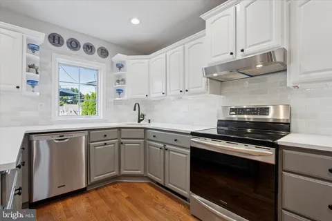 a kitchen with granite countertop cabinets stainless steel appliances and a window