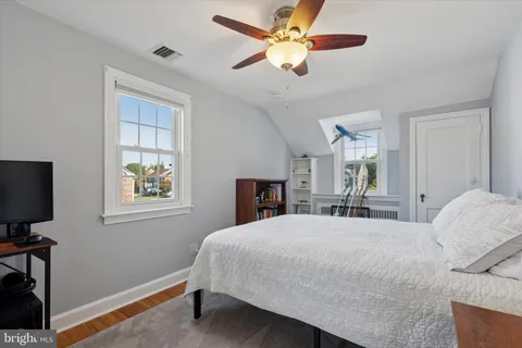 a bedroom with a bed desk and a window