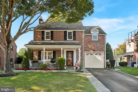 a front view of a house with a yard and potted plants