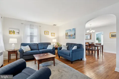 a living room with furniture wooden floor and a window