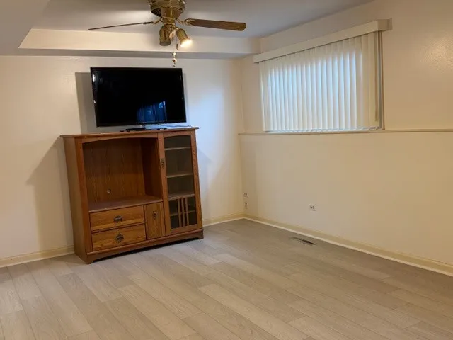 an empty room with cabinet flat screen tv and windows