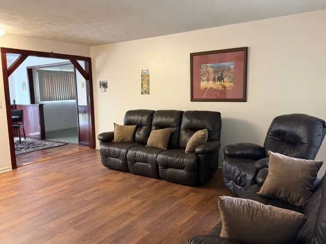 a living room with furniture and a wooden floor