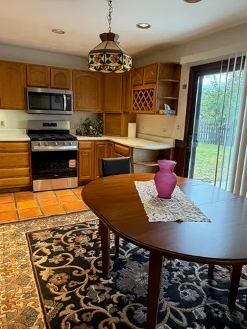 a kitchen with stainless steel appliances granite countertop a stove a sink and a microwave