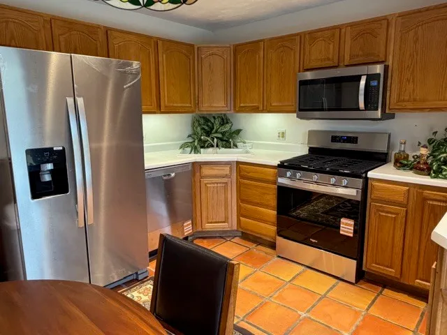 a kitchen with stainless steel appliances granite countertop a refrigerator stove and microwave
