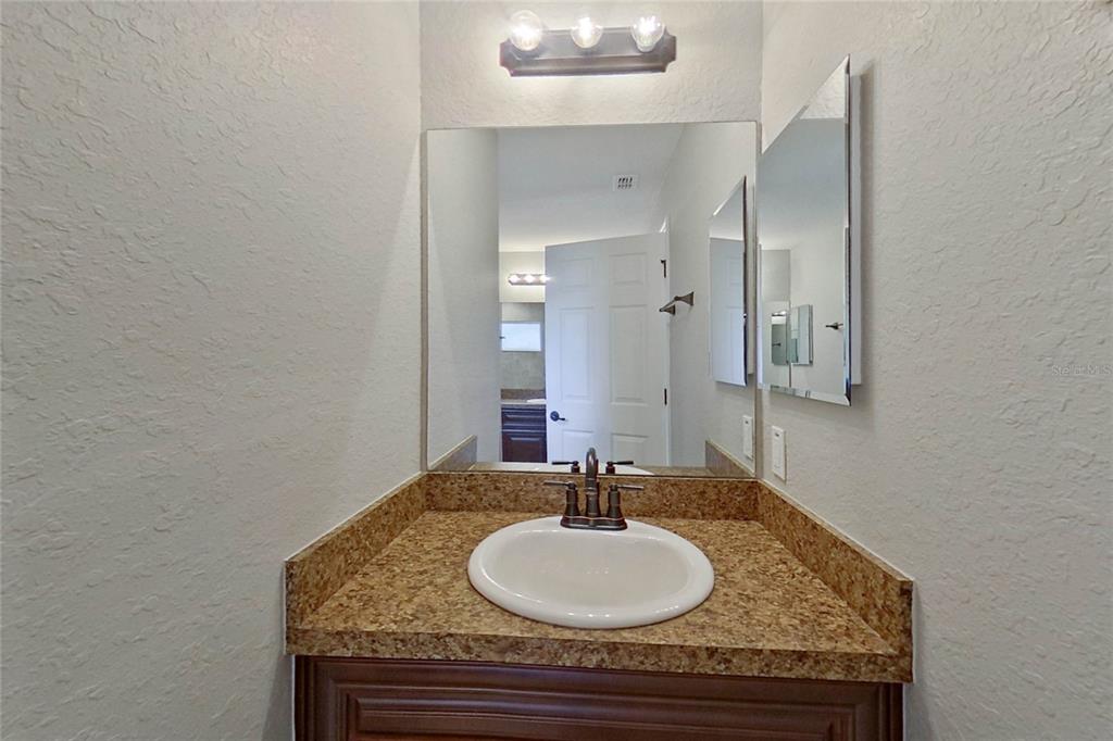 8806 Southwest 135th Street Road Ocala, FL 34473 - Photo 18 of 20 a bathroom with a granite countertop sink and a mirror
