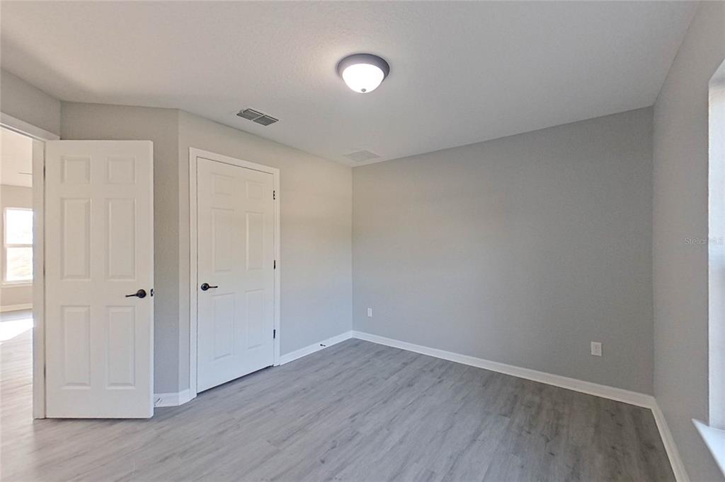 8806 Southwest 135th Street Road Ocala, FL 34473 - Photo 2 of 20 a view of an empty room with wooden floor