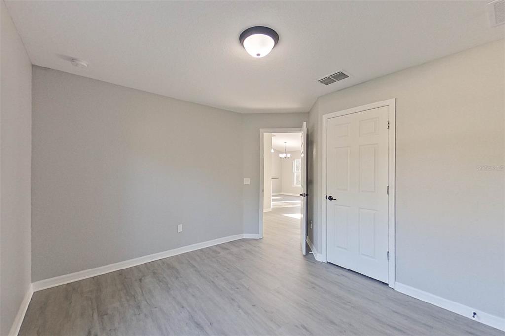 8806 Southwest 135th Street Road Ocala, FL 34473 - Photo 3 of 20 a view of an empty room with wooden floor