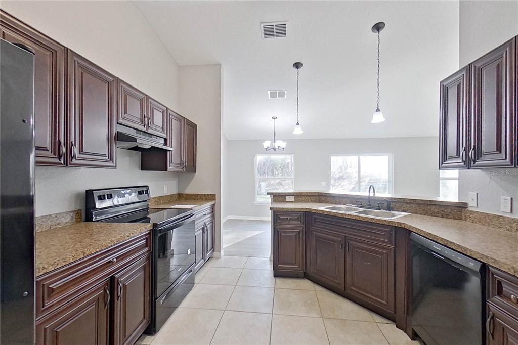 8806 Southwest 135th Street Road Ocala, FL 34473 - Photo 8 of 20 a kitchen with stainless steel appliances granite countertop a sink and stove top oven