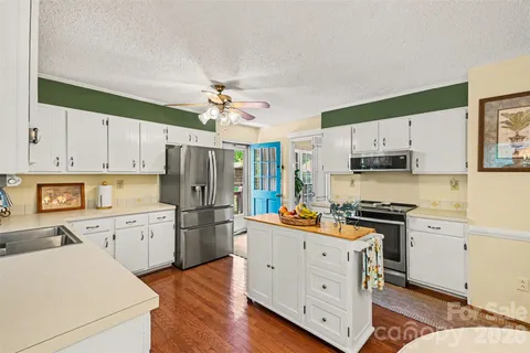 a kitchen with stainless steel appliances a stove refrigerator sink and cabinets