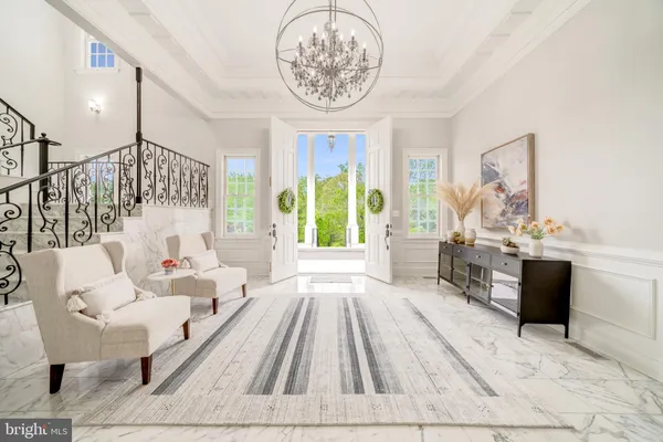 a living room with furniture a fireplace and a chandelier