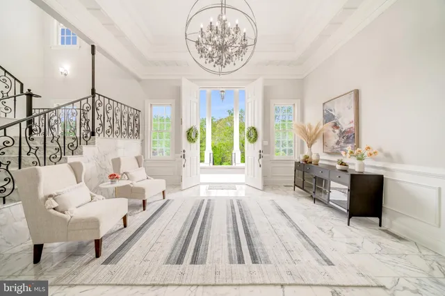 a living room with furniture a fireplace and a chandelier