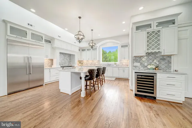 a kitchen with stainless steel appliances kitchen island hardwood floor and a sink