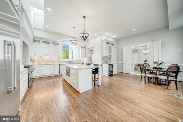 a large white kitchen with lots of counter space dining table and chairs
