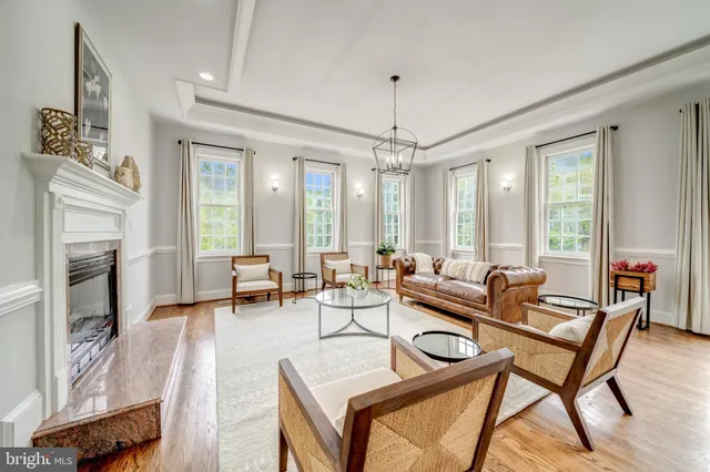 a living room with furniture a fireplace and a chandelier