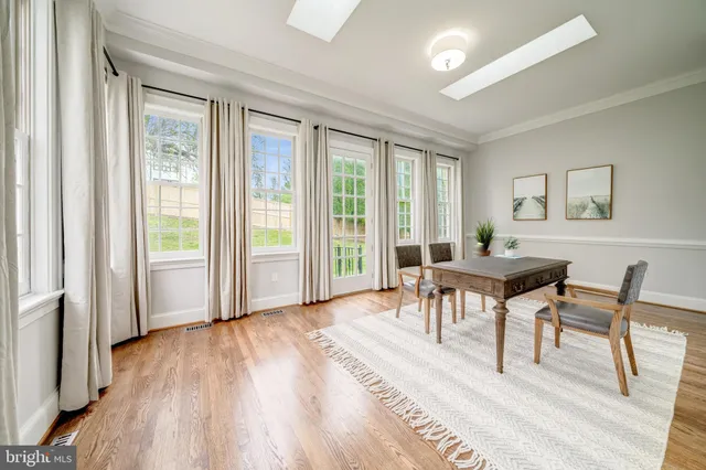 a dining room with wooden floor and furniture