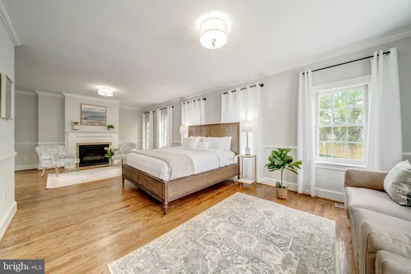 a bedroom with a bed couch and windows