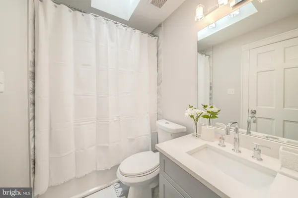 a bathroom with a sink a toilet and a mirror