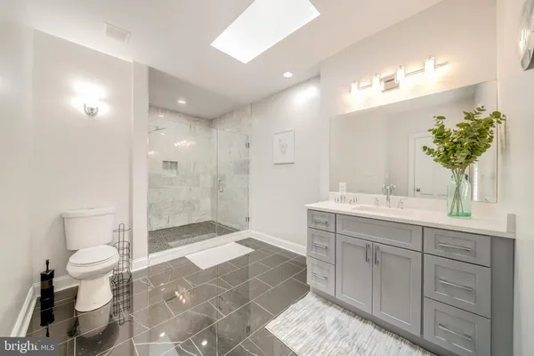 a spacious bathroom with a shower sink mirror and toilet
