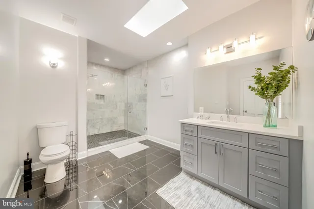 a spacious bathroom with a shower sink mirror and toilet