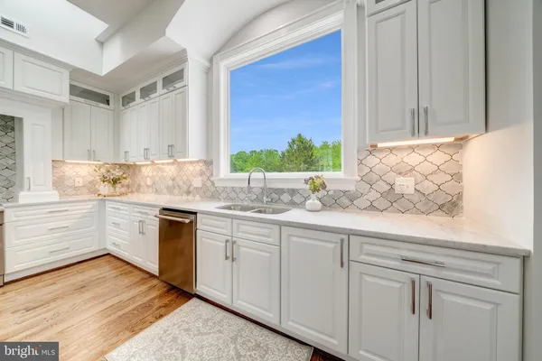 a kitchen with granite countertop white cabinets and white appliances
