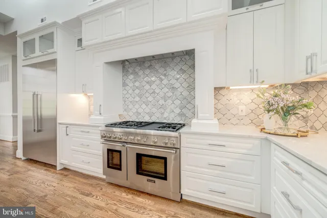 a kitchen with granite countertop white cabinets and stainless steel appliances