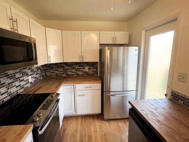 3510 Roswell Road Northwest, Unit J3 Atlanta, GA 30305 - Photo 3 of 17 a kitchen with a refrigerator and a stove top oven