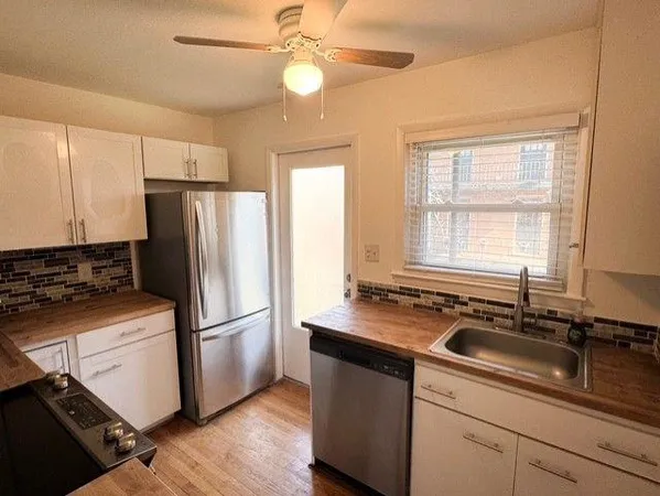a kitchen with a refrigerator a sink and cabinets
