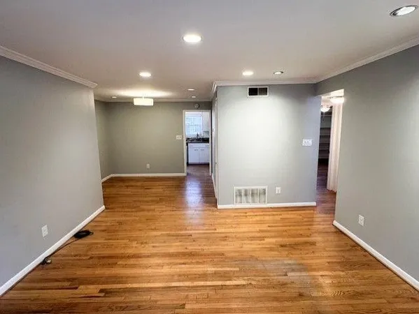 a view of an empty room with wooden floor