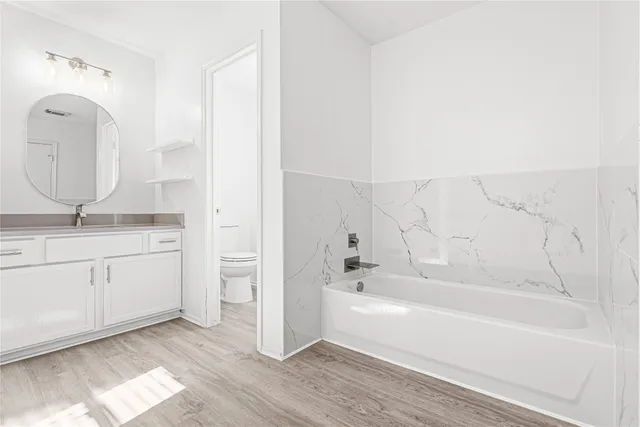 a bathroom with a tub sink and mirror