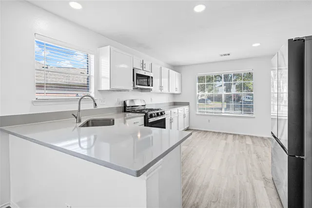 a kitchen with stainless steel appliances granite countertop a sink stove and microwave