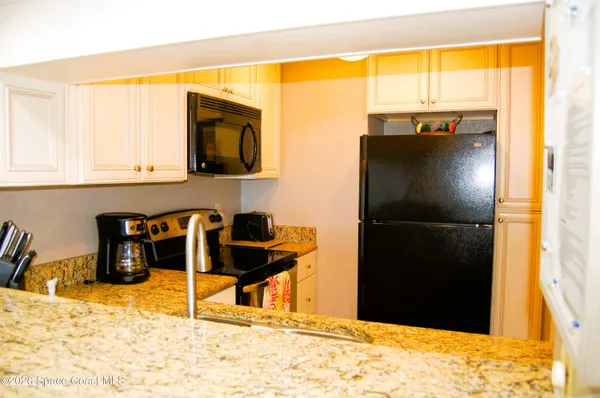 a kitchen with a stove a refrigerator and a table