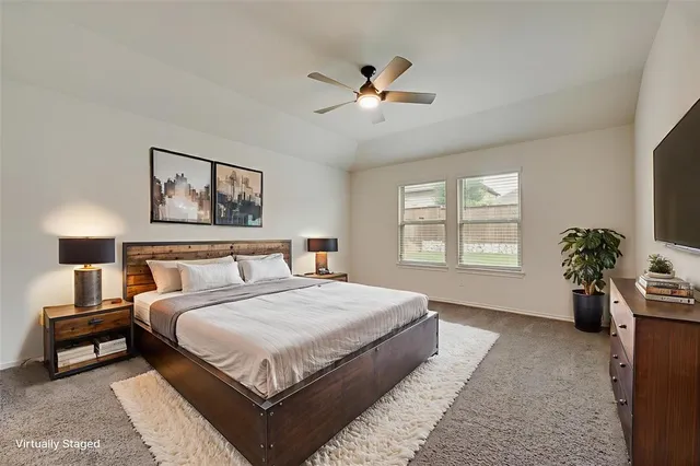a view of a livingroom with a fan a large window with wooden floor