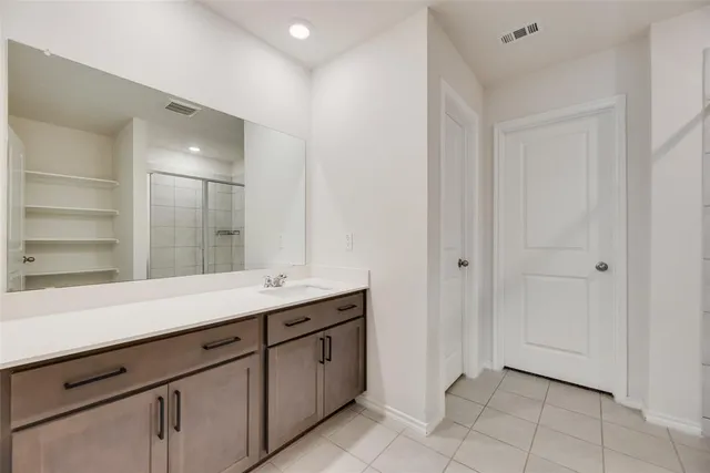 a spacious bedroom with a large bed and a chandelier