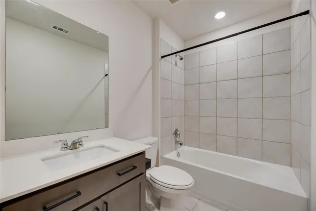 an empty room with a chandelier fan and windows