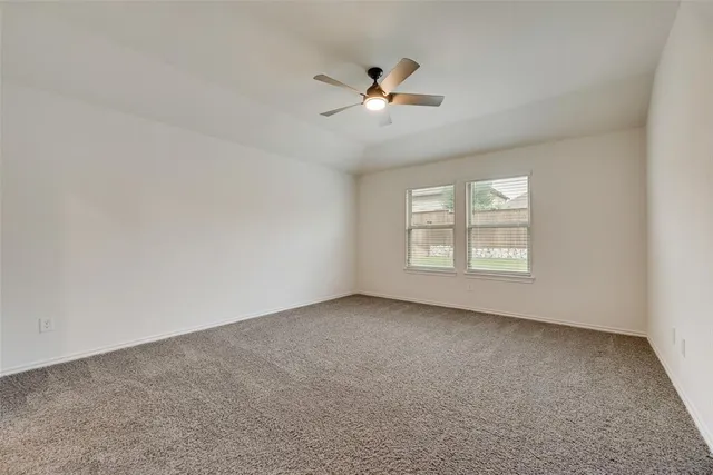 a view of an empty room with kitchen appliances and a window