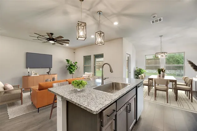 a kitchen with stainless steel appliances granite countertop a sink dishwasher a refrigerator microwave and stove with wooden floor