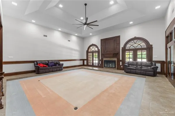a view of a livingroom with a fireplace a ceiling fan and wooden floor